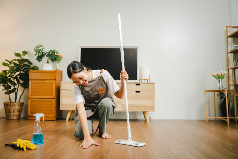 Young housewife is cleaning, wiping and mopping the floor. Clean
