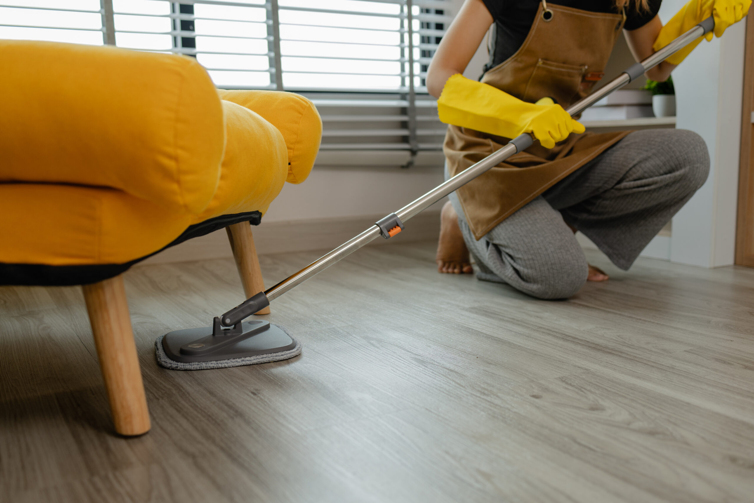 she is mopping floor in living room, as a wife she love to keep the house clean to make sure everyone in her family safe form dust and bacteria, she is cleaning her apartment.